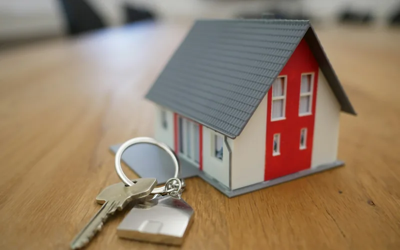 Modellhaus und Schlüsselbund auf einem Holztisch